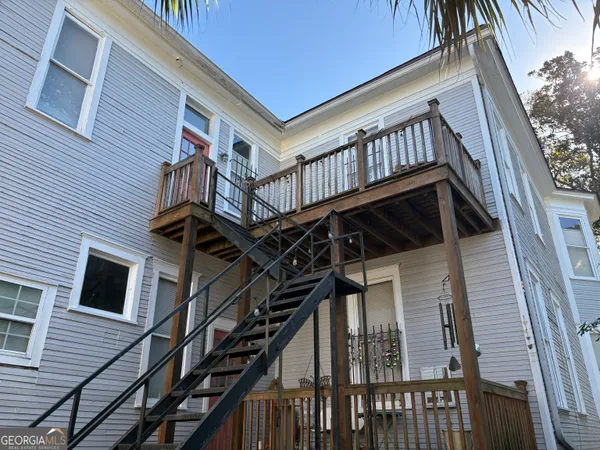 a view of an house with backyard and deck