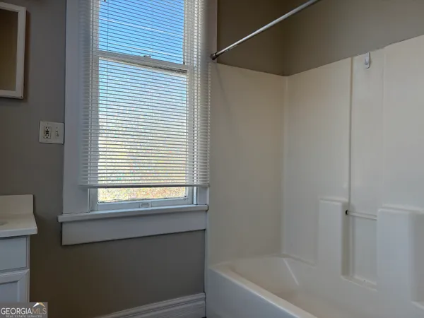 a bathroom with a bathtub and a window