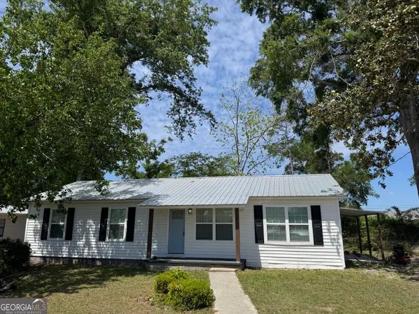a front view of a house with a tree