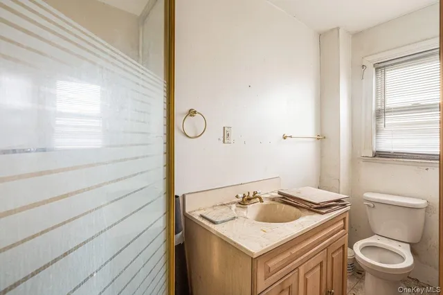 a bathroom with a sink a toilet and window