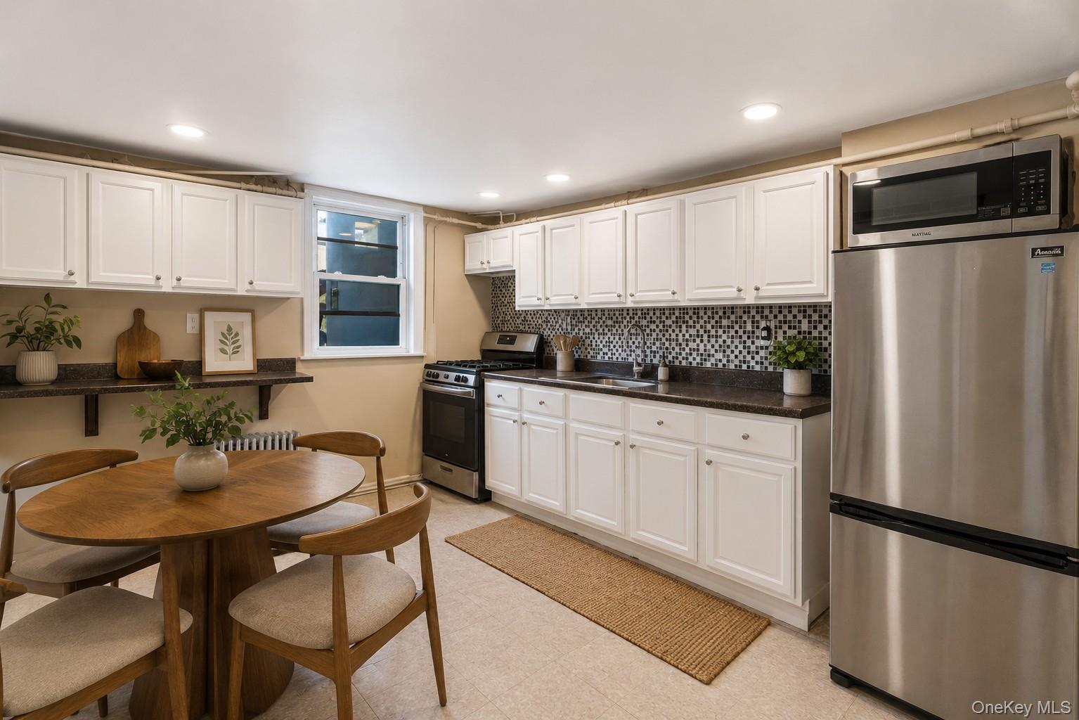57-39 57th Road Queens, NY 11378 - Photo 2 of 31 a kitchen with stainless steel appliances granite countertop a refrigerator a sink a stove a dining table and chairs