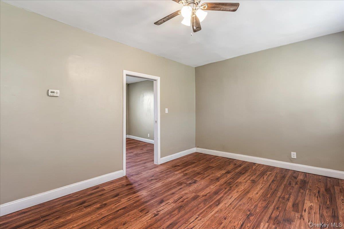 57-39 57th Road Queens, NY 11378 - Photo 22 of 31 an empty room with wooden floor chandelier fan and closet area