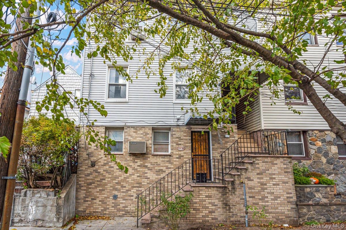 57-39 57th Road Queens, NY 11378 - Photo 26 of 31 front view of a house with a large tree