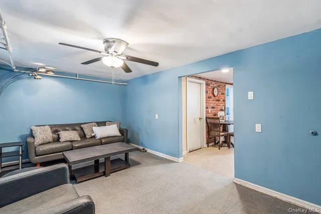 a living room with furniture and a ceiling fan