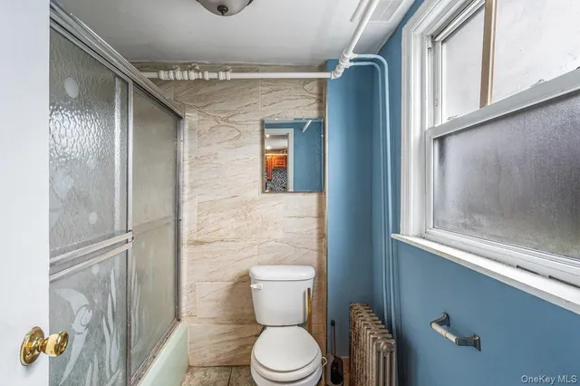 a bathroom with a toilet and a shower