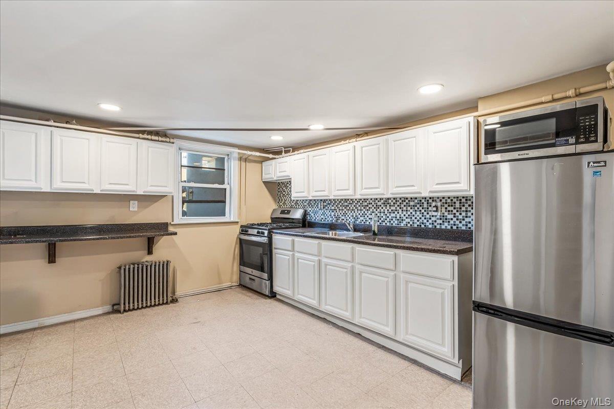 57-39 57th Road Queens, NY 11378 - Photo 10 of 31 a kitchen with stainless steel appliances granite countertop a refrigerator sink and stove