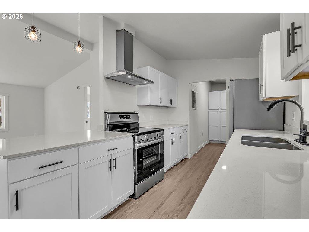 1477 June Way Woodburn, OR 97071 - Photo 12 of 34 a kitchen with stainless steel appliances granite countertop a sink and cabinets