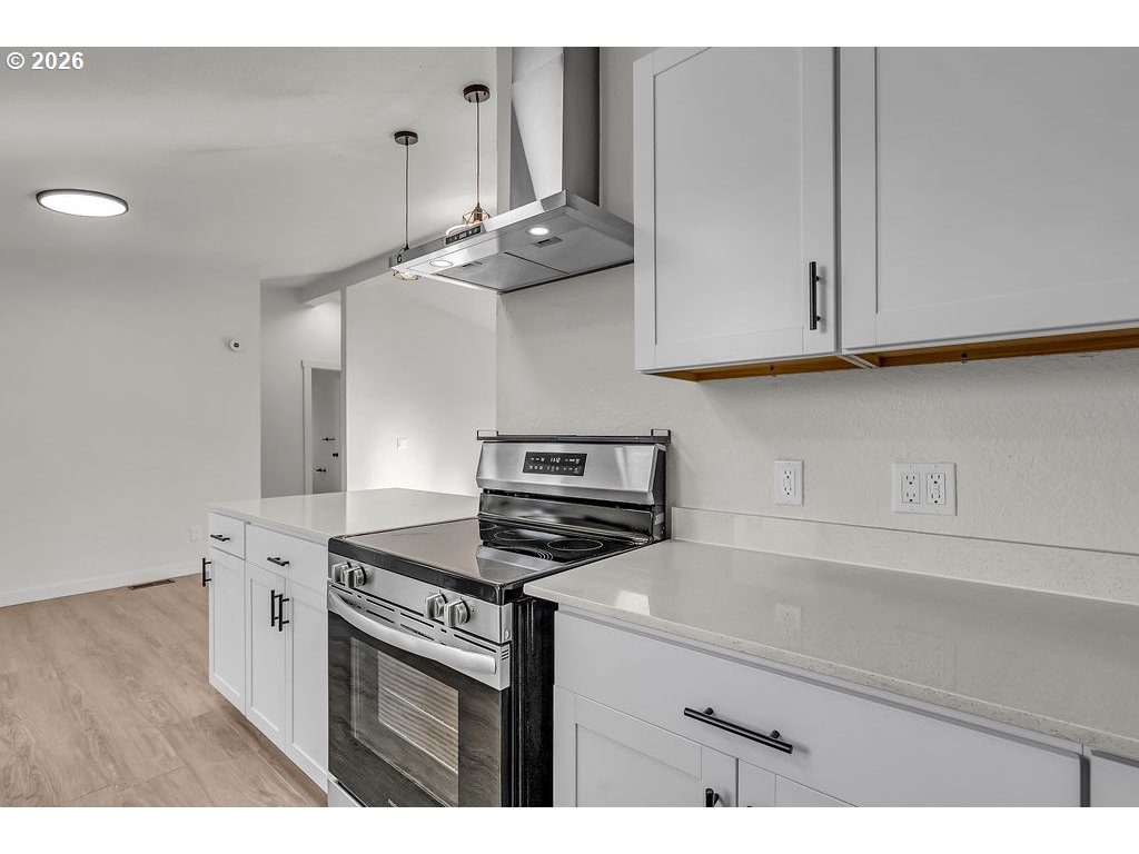 1477 June Way Woodburn, OR 97071 - Photo 13 of 34 a kitchen with stainless steel appliances granite countertop a stove a sink and white cabinets