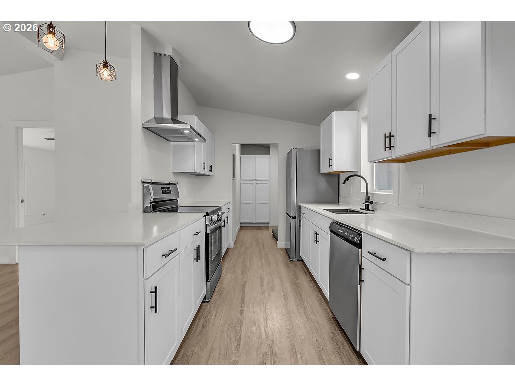 1477 June Way Woodburn, OR 97071 - Photo 15 of 34 a kitchen with stainless steel appliances a sink stove and cabinets