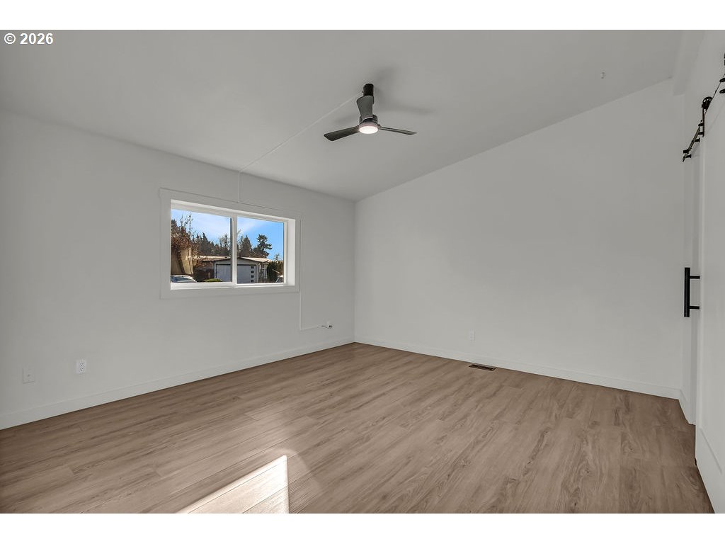 1477 June Way Woodburn, OR 97071 - Photo 18 of 34 a view of an empty room with wooden floor