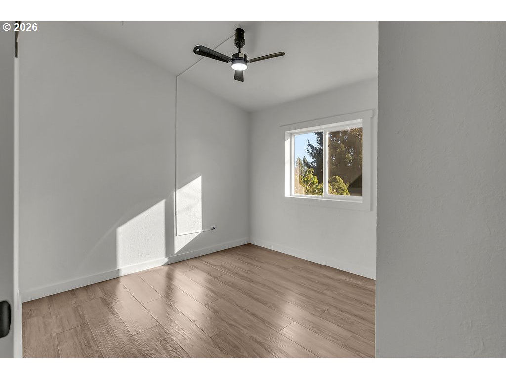 1477 June Way Woodburn, OR 97071 - Photo 23 of 34 a view of an empty room with a window and wooden floor