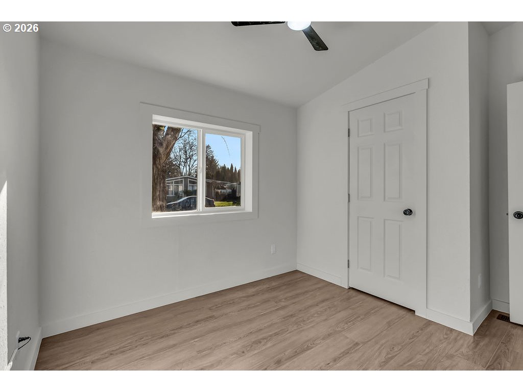 1477 June Way Woodburn, OR 97071 - Photo 24 of 34 a view of an empty room with wooden floor and a window