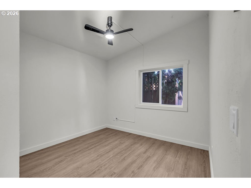 1477 June Way Woodburn, OR 97071 - Photo 25 of 34 a view of an empty room with a window and wooden floor