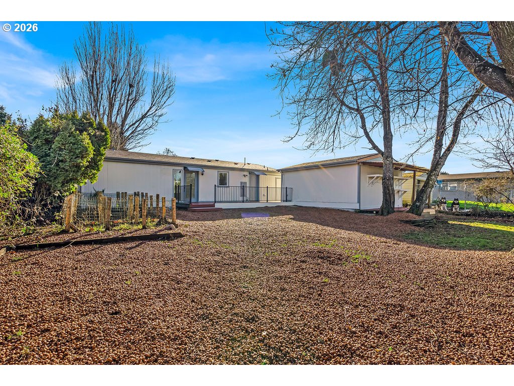 1477 June Way Woodburn, OR 97071 - Photo 31 of 34 a backyard of a house with wooden fence and large trees