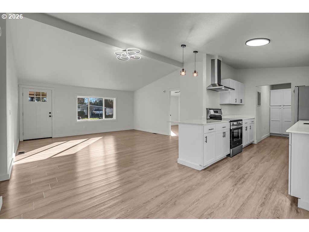 1477 June Way Woodburn, OR 97071 - Photo 10 of 34 a kitchen with stainless steel appliances wooden floors and white cabinets