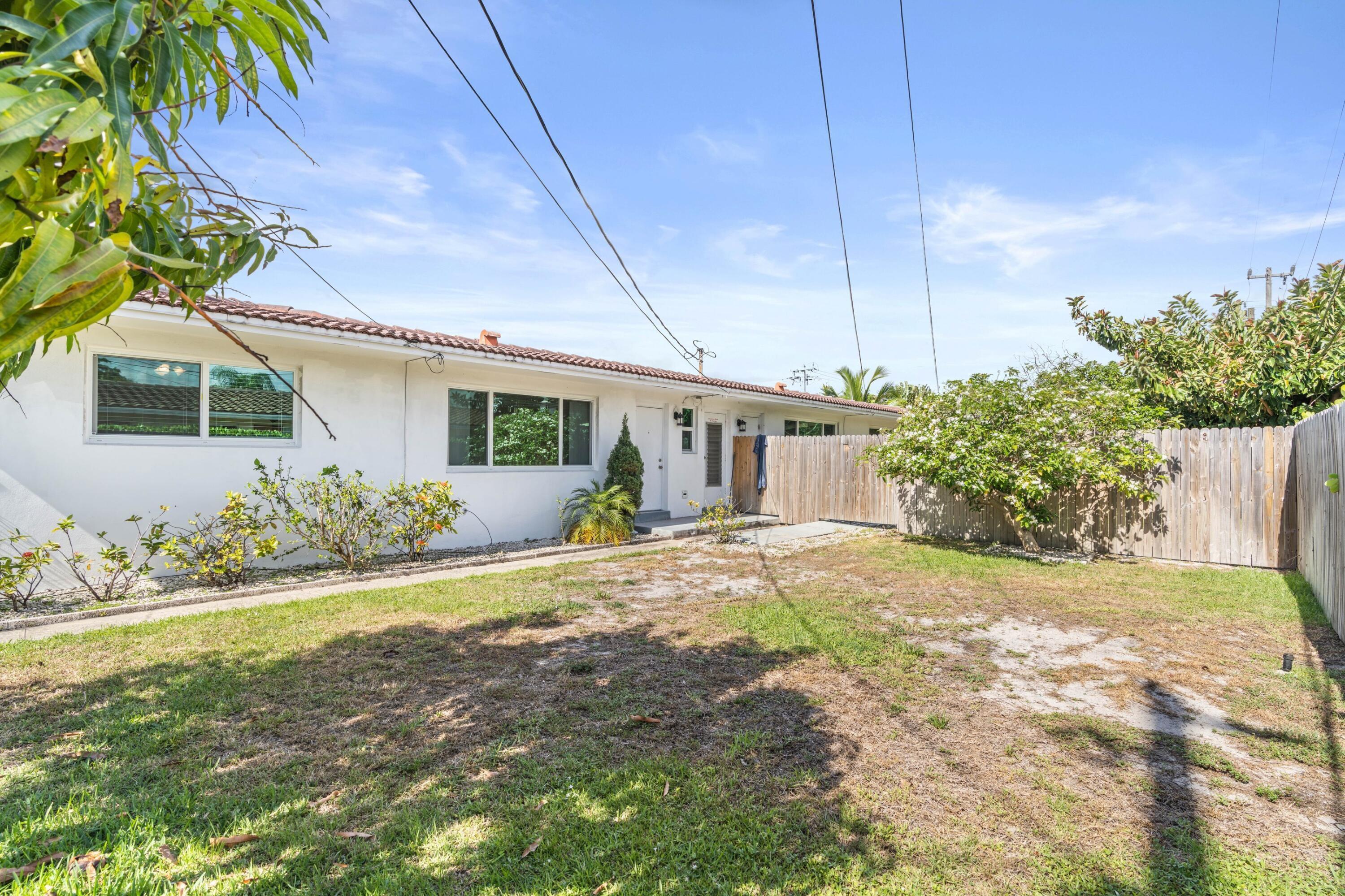 541 Northeast 44th Street, Unit C Boca Raton, FL 33431 - Photo 12 of 16 a view of a house with a yard and potted plants