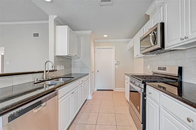 a kitchen with stainless steel appliances granite countertop a sink and stove top oven