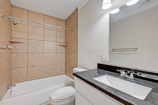 a bathroom with a granite countertop sink toilet mirror and bathtub