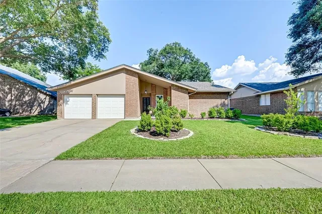 a front view of a house with a yard and potted plants
