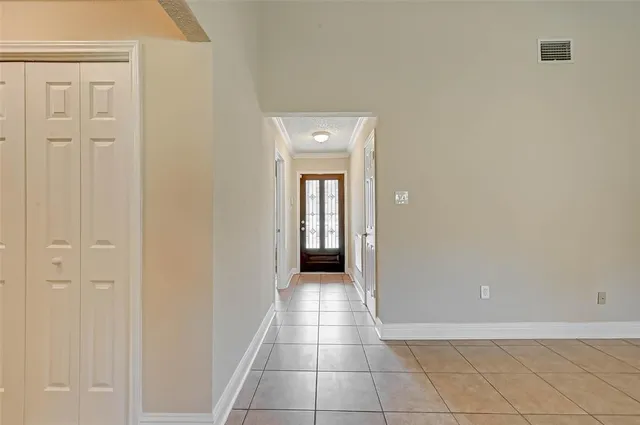 a view of a hallway with wooden floor and a bathroom