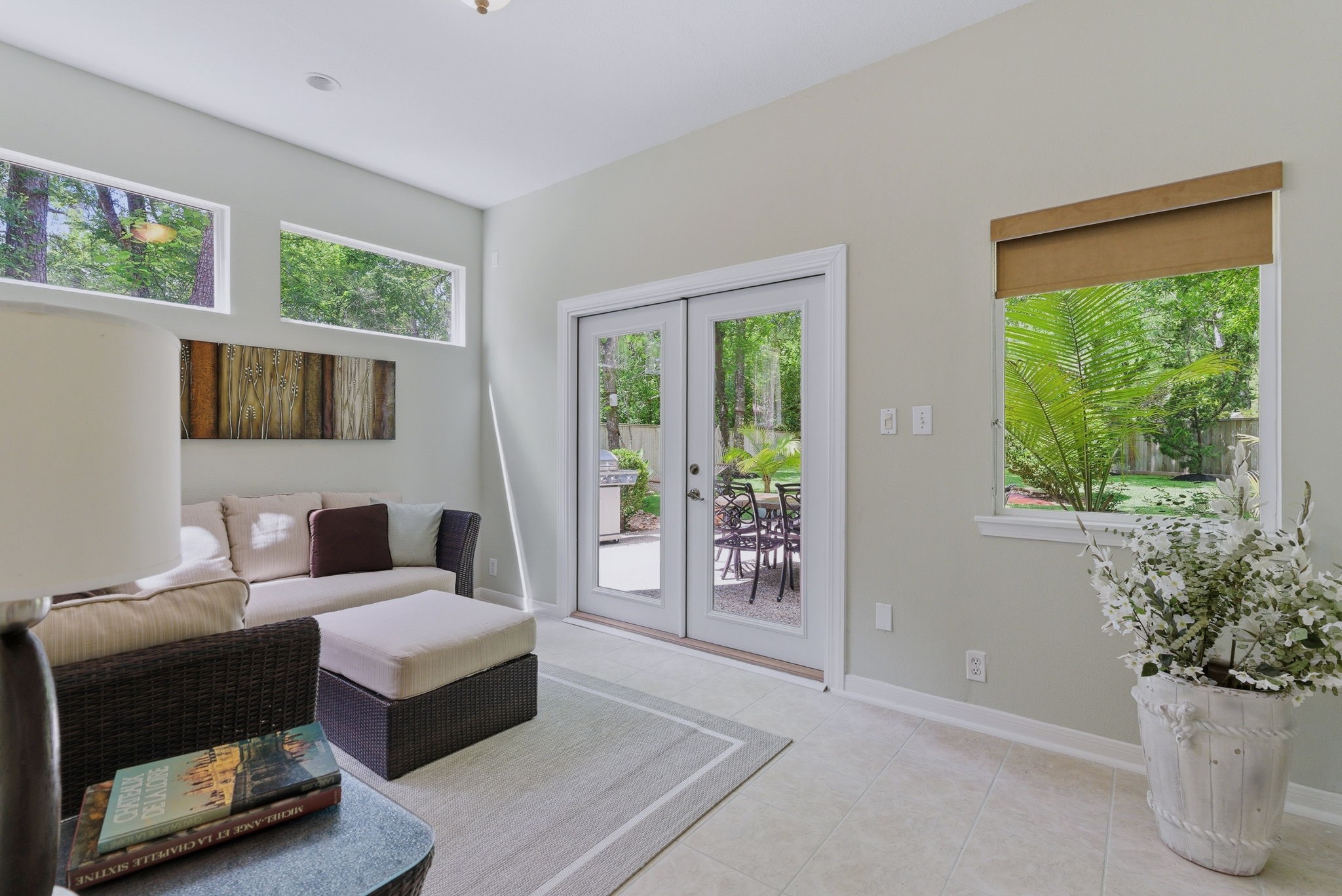 11 Dovewing Place Spring, TX 77382 - Photo 19 of 32 Bright and inviting sunroom with large windows offering natural light and views of lush greenery. French doors open to a charming patio, perfect for indoor-outdoor living.