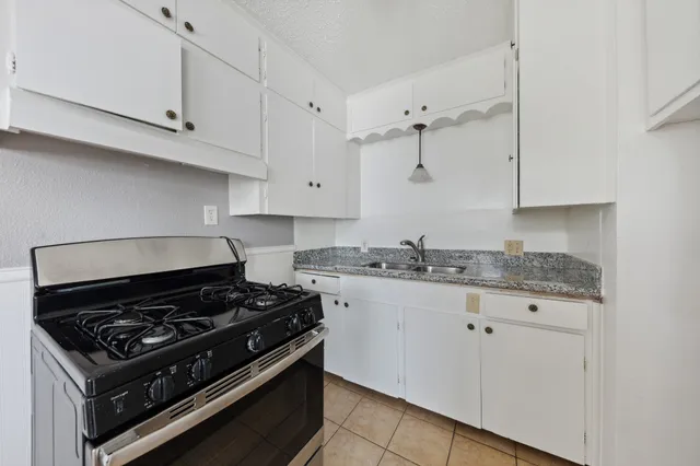 a white stove top oven sitting inside of a kitchen