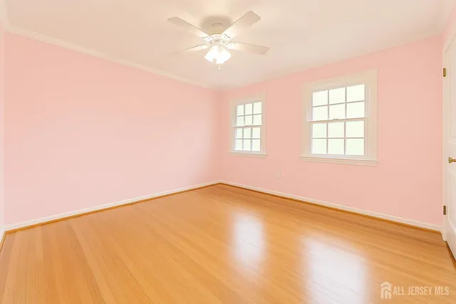 an empty room with windows and ceiling fan