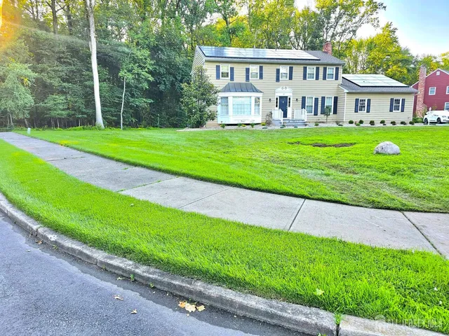 a view of a house with a yard and sitting area
