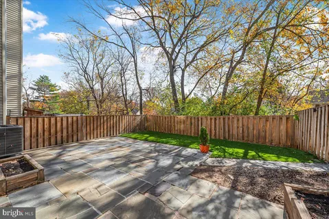 a view of backyard with wooden fence and trees