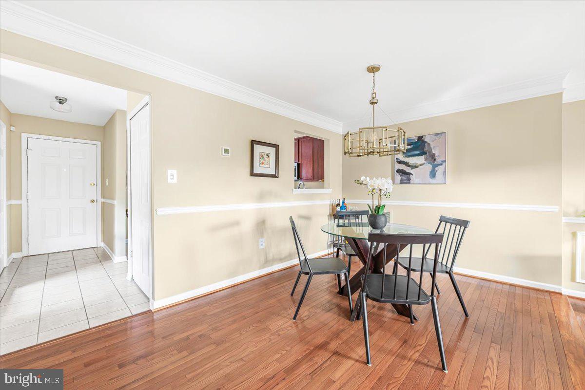1936 Flowering Tree Terrace Silver Spring, MD 20902 - Photo 4 of 26 a view of a dining room with furniture wooden floor and chandelier