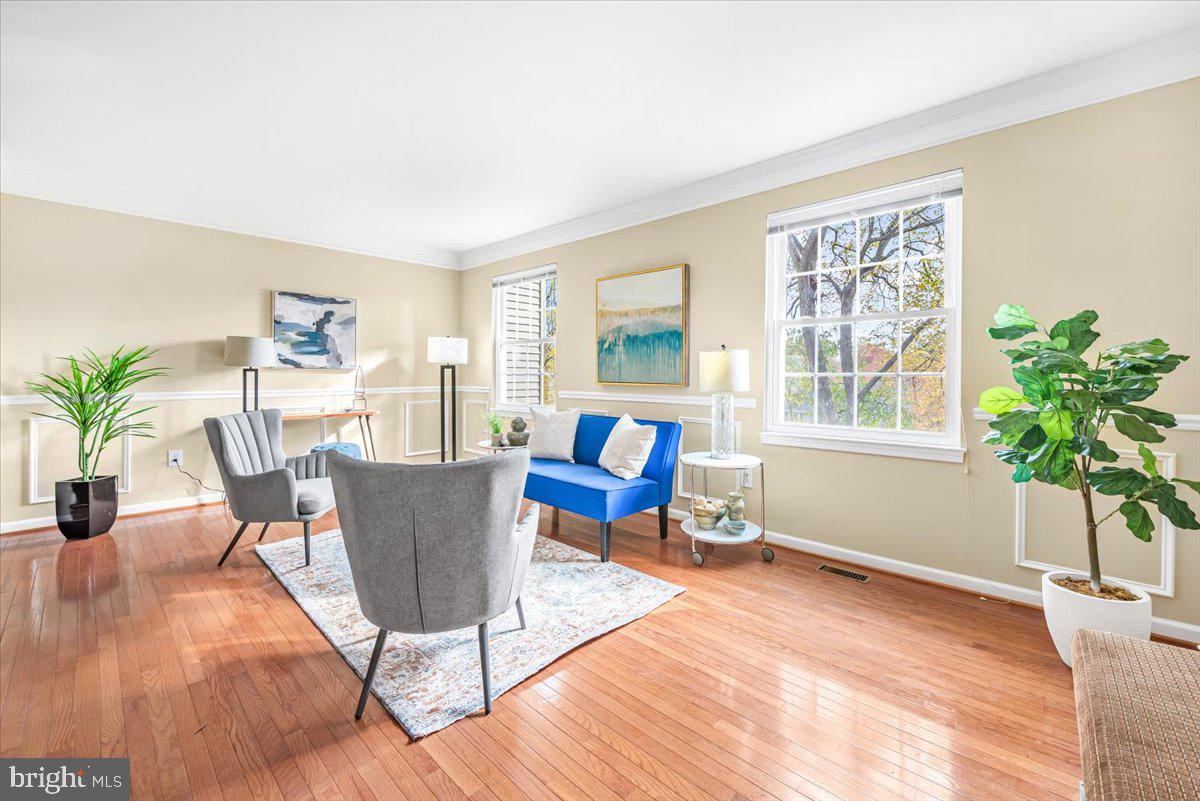 1936 Flowering Tree Terrace Silver Spring, MD 20902 - Photo 5 of 26 a living room with furniture a potted plant and a wooden floor
