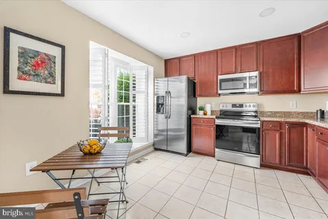 a kitchen with stainless steel appliances a stove a sink a microwave a refrigerator and cabinets