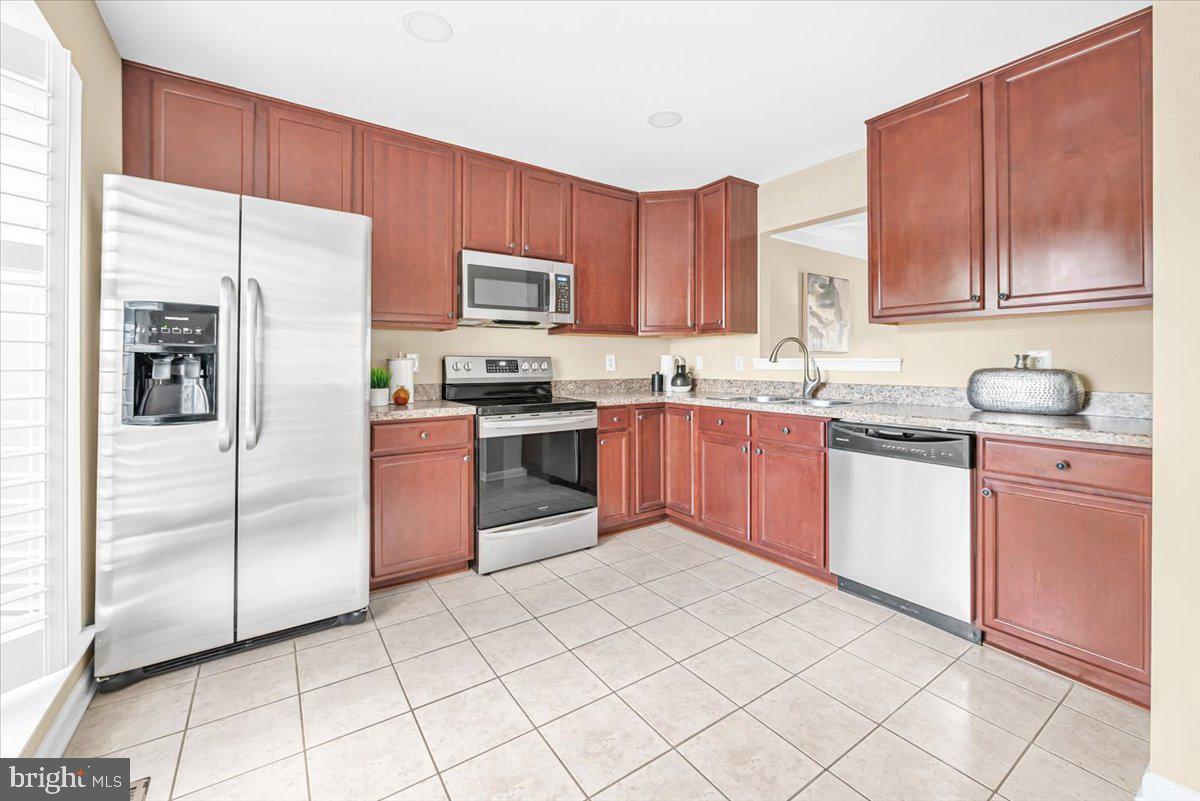 1936 Flowering Tree Terrace Silver Spring, MD 20902 - Photo 8 of 26 a kitchen with stainless steel appliances granite countertop a stove a sink dishwasher a refrigerator and cabinets with wooden floor