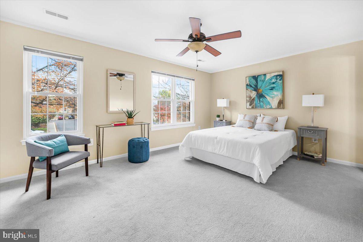 1936 Flowering Tree Terrace Silver Spring, MD 20902 - Photo 9 of 26 a bedroom with a bed a couch and a window