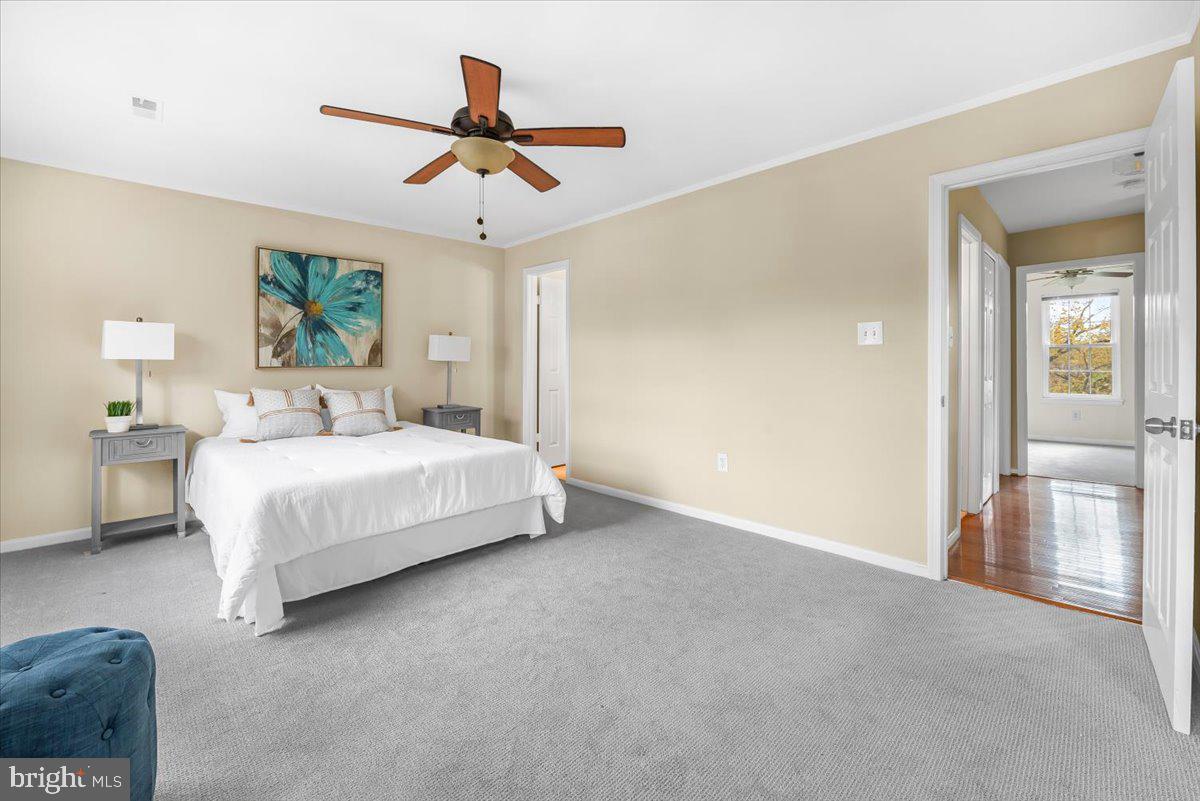 1936 Flowering Tree Terrace Silver Spring, MD 20902 - Photo 10 of 26 a spacious bedroom with a bed and a chandelier