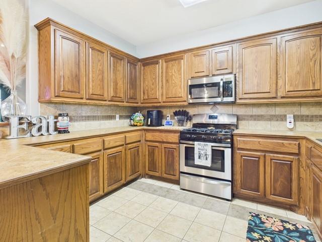 1675 Meadowview Street Athens, TX 75752 - Photo 13 of 40 a kitchen with stainless steel appliances granite countertop a stove sink and cabinets
