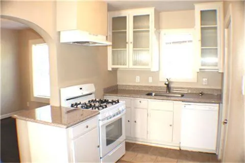 a kitchen with granite countertop a sink stove and cabinets