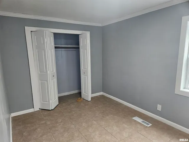 a view of an empty room with closet area