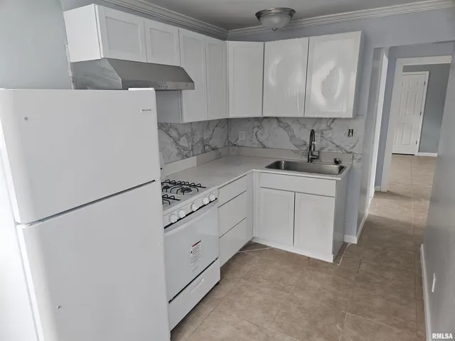 a kitchen with cabinets appliances a sink and a counter space