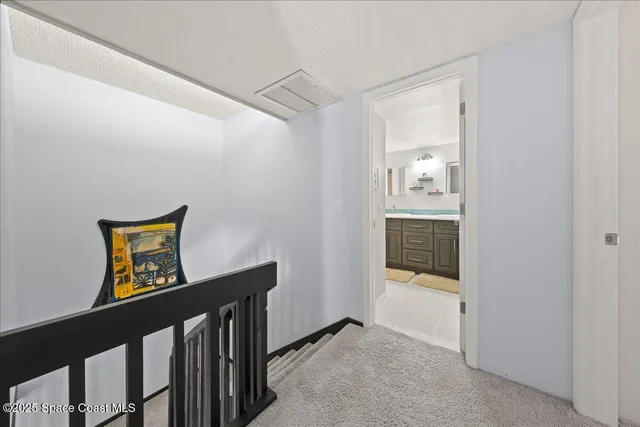 a view of a hallway to a livingroom with wooden floor and furniture