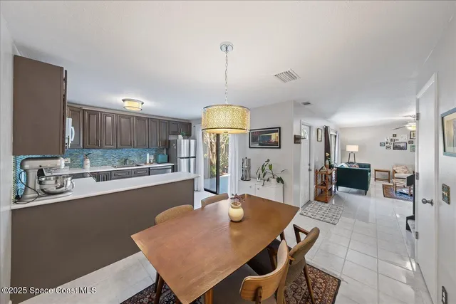 a dining room filled chandelier and kitchen view
