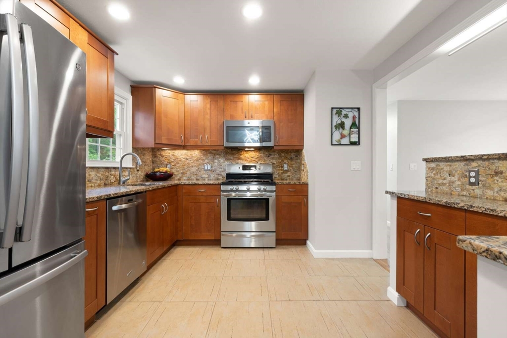 18 Winsor Road Billerica, MA 01821 - Photo 11 of 28 a kitchen with stainless steel appliances granite countertop a stove a sink and a refrigerator