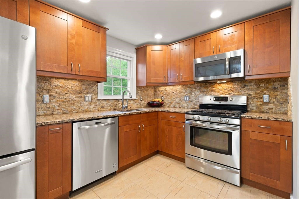 18 Winsor Road Billerica, MA 01821 - Photo 13 of 28 a kitchen with stainless steel appliances granite countertop a stove a sink and a microwave