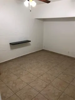 an empty room with a chandelier fan