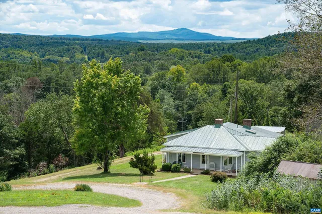 a view of house with yard and outdoor seating