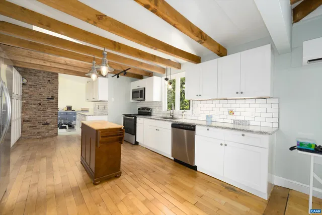 a kitchen with granite countertop a sink cabinets stainless steel appliances and a counter top space