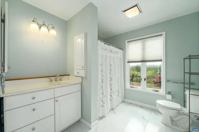 a spacious bathroom with a double vanity sink toilet and shower