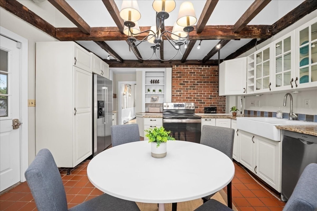 19 Gilmore Road Southborough, MA 01772 - Photo 7 of 42 a kitchen with stainless steel appliances granite countertop a white refrigerator a sink a dining table and chairs