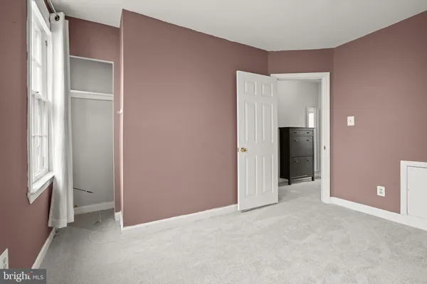 an empty room with closet and a window