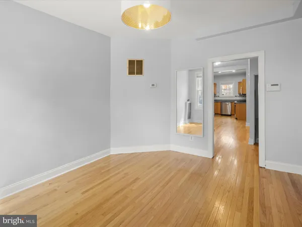 a view of a big room with wooden floor and windows